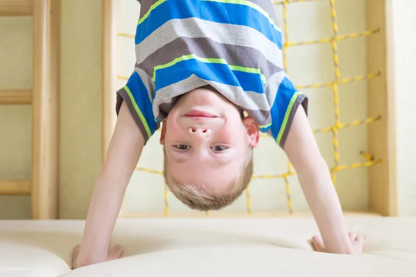 Boy standing upside down in gym class. — Stock Photo, Image