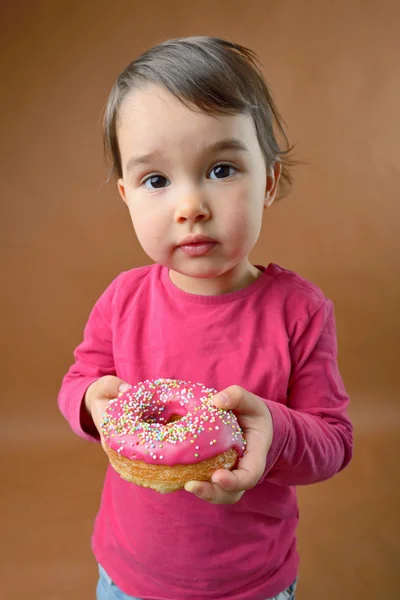 Liten flicka med donut — Stockfoto