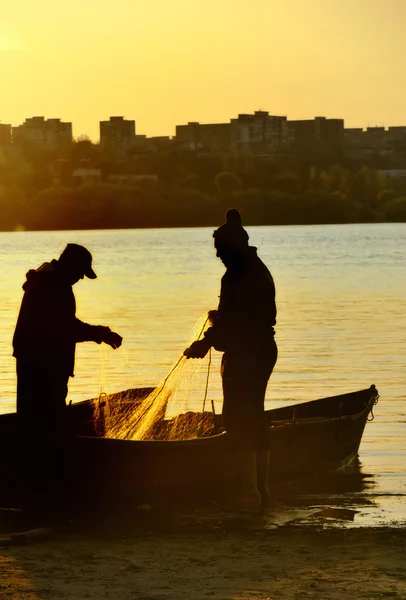 Silhouette de pêcheurs au coucher du soleil — Photo