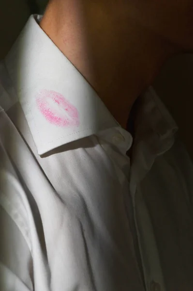 Lipstick marks on the collar of a men\'s white dress shirt