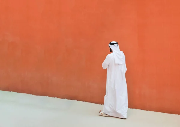 Arabský Muž Tradičními Emiráty Oblečení Procházející Venku Ulici Proti Oranžové — Stock fotografie