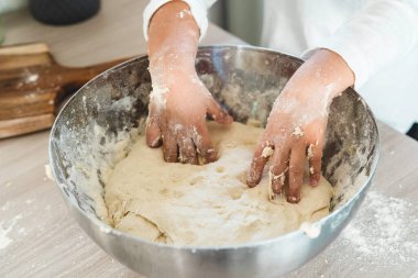 Pizzanın, ekmeğin ya da kekin karışımını yoğuran küçük kızın ellerine yakın çekim - un, mayanın mayası, zeytinyağı ve su hamuru tamamlamak için - çocukluk kavramı ve küçük aşçılar