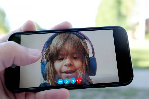 Baba ve kızı akıllı telefondan birbirleriyle konuşuyorlar ellerinde akıllı bir telefonla küçük bir kız yüzü, mesafeli bir ilişki çocukluk kavramı boşanmış bir baba.
