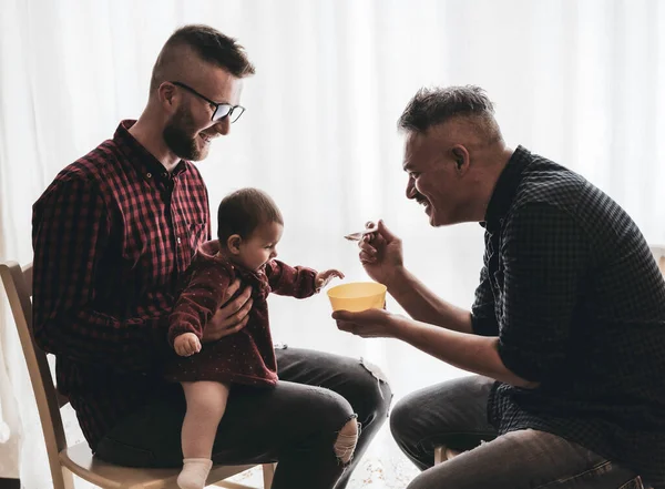 Evlatlık kızı olan erkek eşcinsel çift - iki yakışıklı baba mutfakta bebeğe bakıyor - erkek bakıcılar - Lgbt ailesi evde - çeşitlilik kavramı