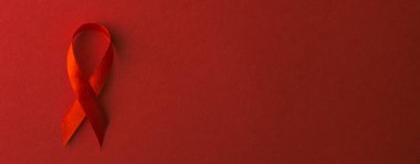 Kırmızı kurdele sembolü HIV, AIDS kanseri gölgeli farkındalık, kırmızı arka planda izole edilmiş stüdyo çekimi, sağlık sigortası konsepti, Dünya AIDS Günü