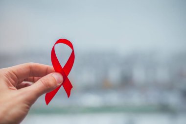 Kırmızı kurdele sembolü HIV, AIDS kanseri gölgeli farkındalık, kırmızı arka planda izole edilmiş stüdyo çekimi, sağlık sigortası konsepti, Dünya AIDS Günü