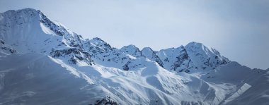 Güneşli bir günde yüksek karlı dağlarda panoramik manzara. Kafkas Dağları, Ushba Dağı. Gürcistan 'ın Svaneti bölgesi