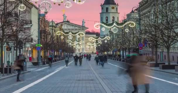 Abends in der Gediminas-Allee gehen die Menschen geduckt durch die Straßen. Zeitraffer der Weihnachtszeit in Vilnius, Litauen — Stockvideo