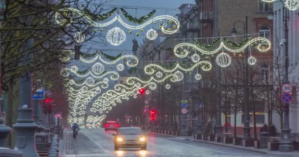 Avond in de Gediminas laan, auto 's rijden en mensen lopen door de straten. Het verstrijken van de kersttijd In Vilnius, Litouwen — Stockvideo