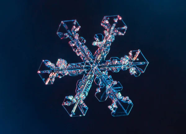 Schneeflocke auf glattem Gradienten-Hintergrund. Makroaufnahme von echtem Schneekristall auf Glasoberfläche. Das ist eine kleine Schneeflocke mit ungewöhnlichem Muster. — Stockfoto