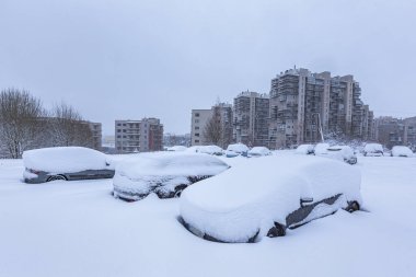 Otoparktaki kar fırtınasında araçlar karla kaplı.