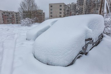 Otoparktaki kar fırtınasında araçlar karla kaplı.