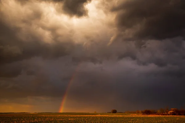 Nuvens de tempestade com arco-íris na luz do pôr-do-sol — Fotografia de Stock