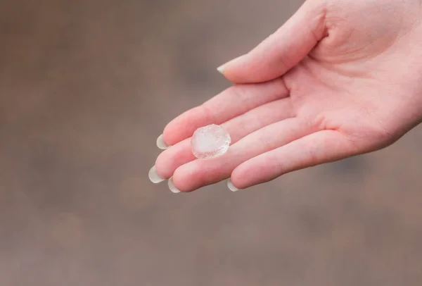 Hailstone em uma mão de mulheres depois da tempestade forte — Fotografia de Stock