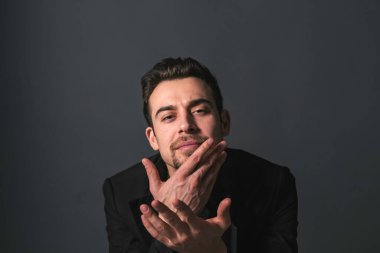 Siyah ceketli beyaz bir adamın stüdyo resmi. Kameraya bakıyor. Stüdyonun arka planına bakıyor.