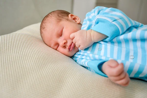 Baby lying on a bed while sleeping in a bright room — Stock Photo, Image