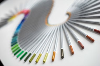 Beyaz arka plan üzerinde izole bir dalga düzenlenen renkli kalemler