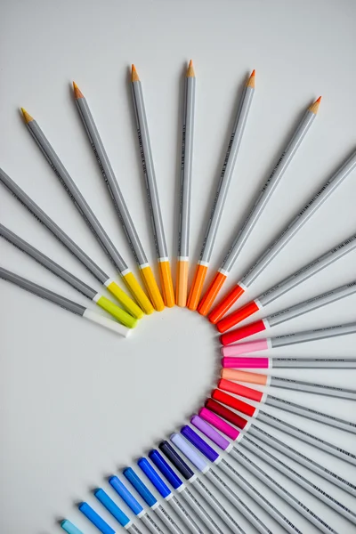 Lápis coloridos dispostos em uma onda isolada sobre fundo branco — Fotografia de Stock