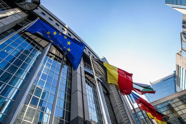 Waiving flags in front of European Parliament building. Brussels, Belgium