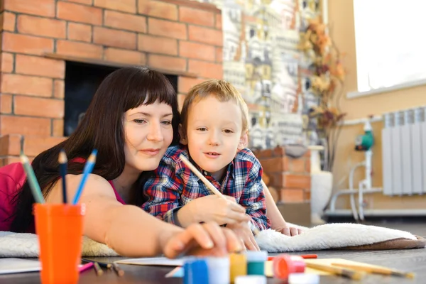 Mãe com seu filho pintando em casa — Fotografia de Stock