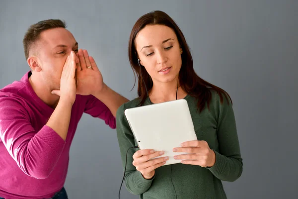 Fiatal nő fejhallgató és sikoltozik a fülébe az ember — Stock Fotó