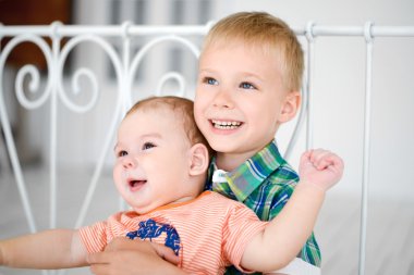 Bir yatağa oturmuş iskambil kardeş