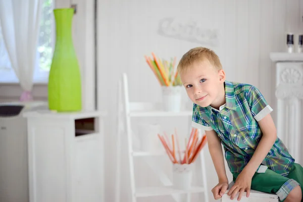 Portret szczęśliwy blond chłopiec dziecko siedzi na krześle — Zdjęcie stockowe