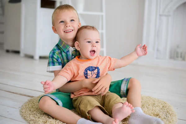 Twee kinderen spelen zittend op de vloer thuis — Stockfoto