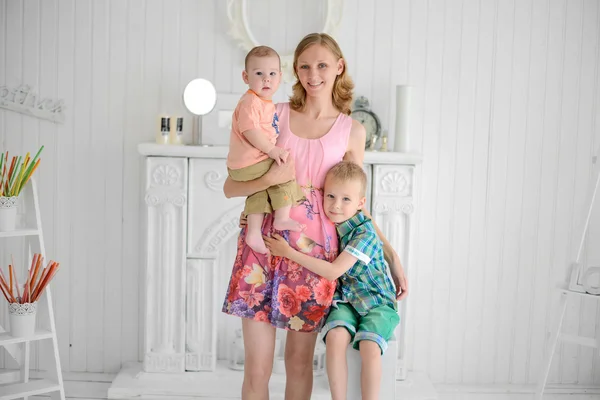 Bonita mãe de pé com seus filhos em casa — Fotografia de Stock