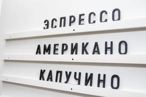 Кав'ярня білий стіл з асортиментом. Вивіска кав'ярні з написами — стокове фото