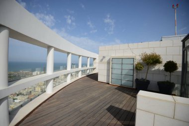 İsrail. Tel Aviv 'de. 15 Nisan 2015 'te. Pahalı konutlar. Milyonerlerin bölgesi. Bir gökdelenin çatısından bak. Teras, balkon ya da loggianın açık ya da yarı açık alanı.