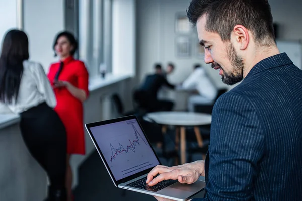 Fotografía de un joven empresario trabajando en una laptop en una oficina — Foto de Stock