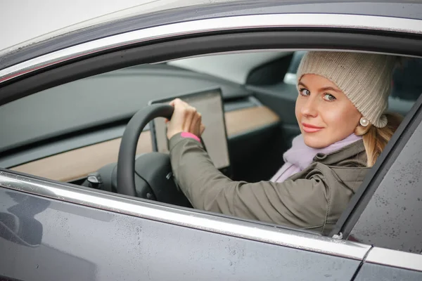 Mulher dirigindo um carro elétrico — Fotografia de Stock