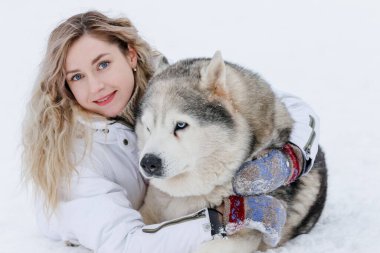 Sibirya kurdu tarafından çekilen kızağa binen bir kız. Husky kızak köpekleri Noel 'de olduğu gibi kayak yaparken de kullanılıyor..