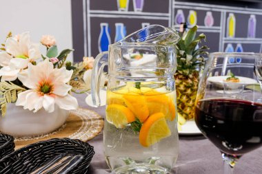 Bir sürahi portakal ve nane arkaplanlı çiçek..