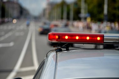 Vizon. BELARUS - HAZİRAN 2016: Bir polis aracının arka planında kırmızı ışıklar yanıp sönüyor.