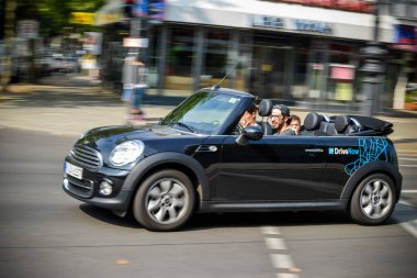 ALMANY - AĞUSTOS 2015: DriveNow adlı bir şirketten kiralama için bir Minicooper 'ın üzerindeki şirket tabelasına yakın çekim. Araba kiralama bir mobil uygulama aracılığıyla gerçekleştirilir.