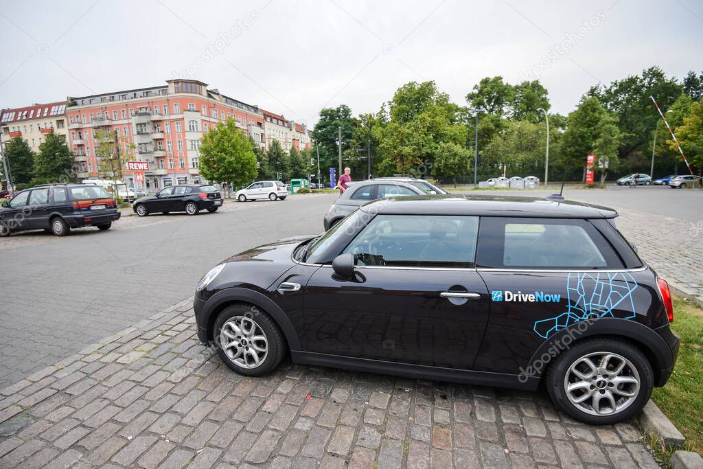 GERMANY - AUGUST 2015: Car sharing car in the parking lot in the city. Close-up of a company sign on Minicooper for rent from DriveNow. Car rental takes place through a mobile application.