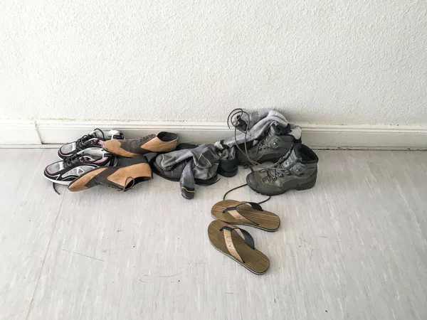 GERMANY - MAY 2016: Shoes on the floor, sneakers, slippers, sandals, bats on a light floor near a white wall. — Stock Photo, Image