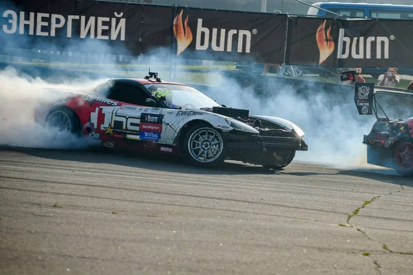 BELARUS. MINSK - LIPIEC 2016: Nieznany zawodnik w wagonie driftowym pokonuje tor Mistrzostw Białorusi Drift Championship w Mińsku. Berno logo napoju energetycznego. — Zdjęcie stockowe