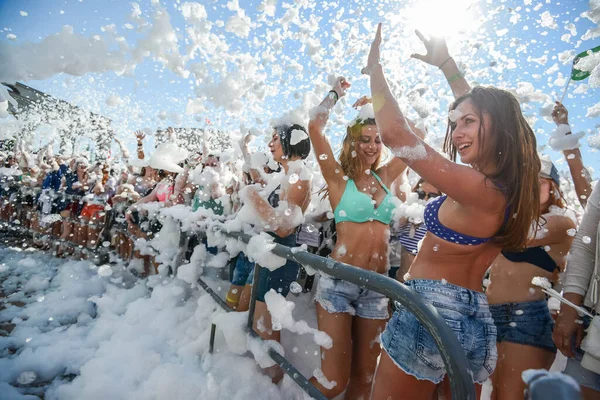 MINSK. BELARO - giugno 2016: la schiuma al partito vola alla gente allegra. schiuma partito divertente, la gente allegramente alza le mani, prendere bolle di sapone, festival di intrattenimento estivo in acqua — Foto Stock