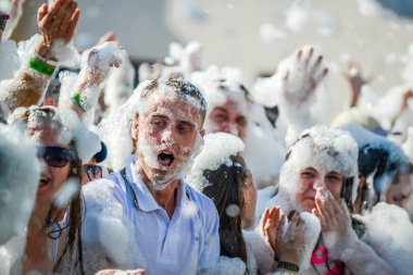 Vizon. BELARUS - Haziran 2016: Bir partide köpük içinde mutlu insanların portreleri. Köpüklü eğlence partisi, insanlar sevinçle ellerini kaldırır, sabun köpükleri yakalar, suda yaz eğlencesi festivali düzenlerler.