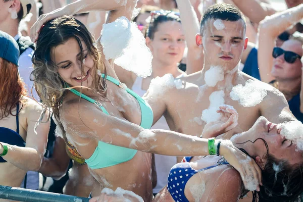 ミンスク。BELARUS - June 2016:パーティーで泡の中の幸せな人々の肖像画。泡の歓楽街人は手を挙げてシャボン玉を捕まえる水の中の夏の娯楽祭 — ストック写真