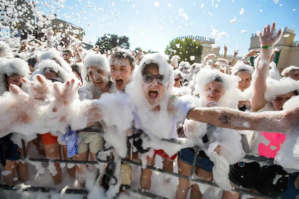 MINSK. BELARUS - Juin 2016 : Portraits de personnes heureuses en mousse lors d'une fête. fête divertissante en mousse, les gens lèvent joyeusement les mains, attraper des bulles de savon, festival de divertissement d'été dans l'eau — Photo