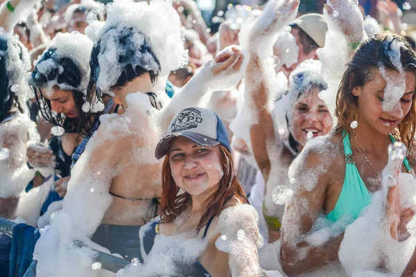 ミンスク。BELARUS - June 2016:パーティーで泡の中の幸せな人々の肖像画。泡の歓楽街人は手を挙げてシャボン玉を捕まえる水の中の夏の娯楽祭 — ストック写真