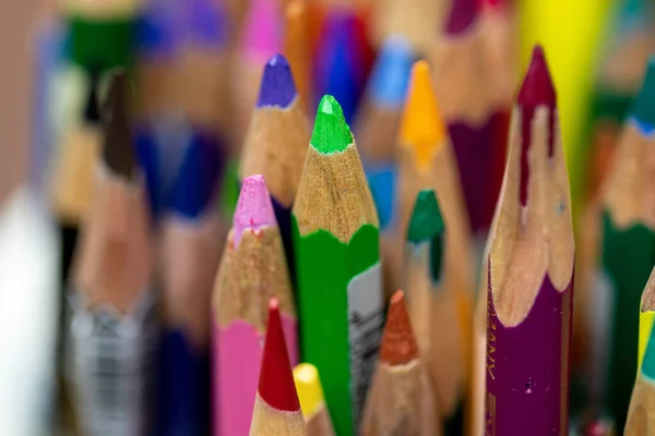 Voltar ao conjunto da escola lápis multicolorido colorido fazendo formas vista lateral em um fundo amarelo — Fotografia de Stock