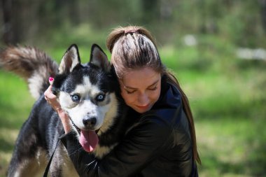 Şirin kız bir Husky 'ye sarılıyor. Husky çok iyi arkadaştır..