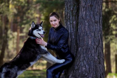 Çekici kız ormanda boğuk bir köpekle oynuyor..