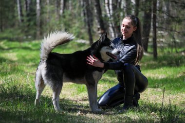 Şirin kız bir Husky 'ye sarılıyor. Husky çok iyi arkadaştır..