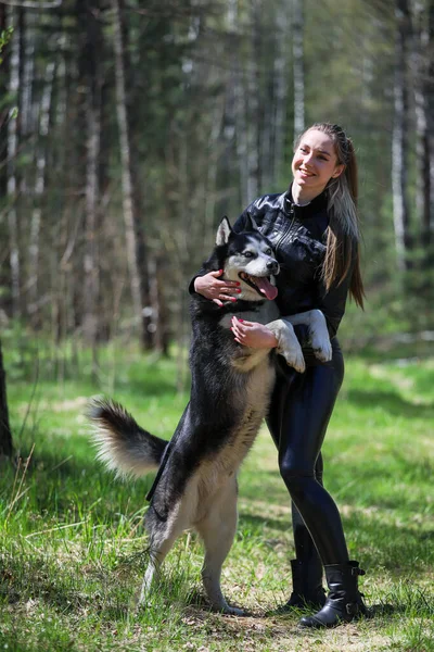 Şirin kız bir Husky 'ye sarılıyor. Husky çok iyi arkadaştır..